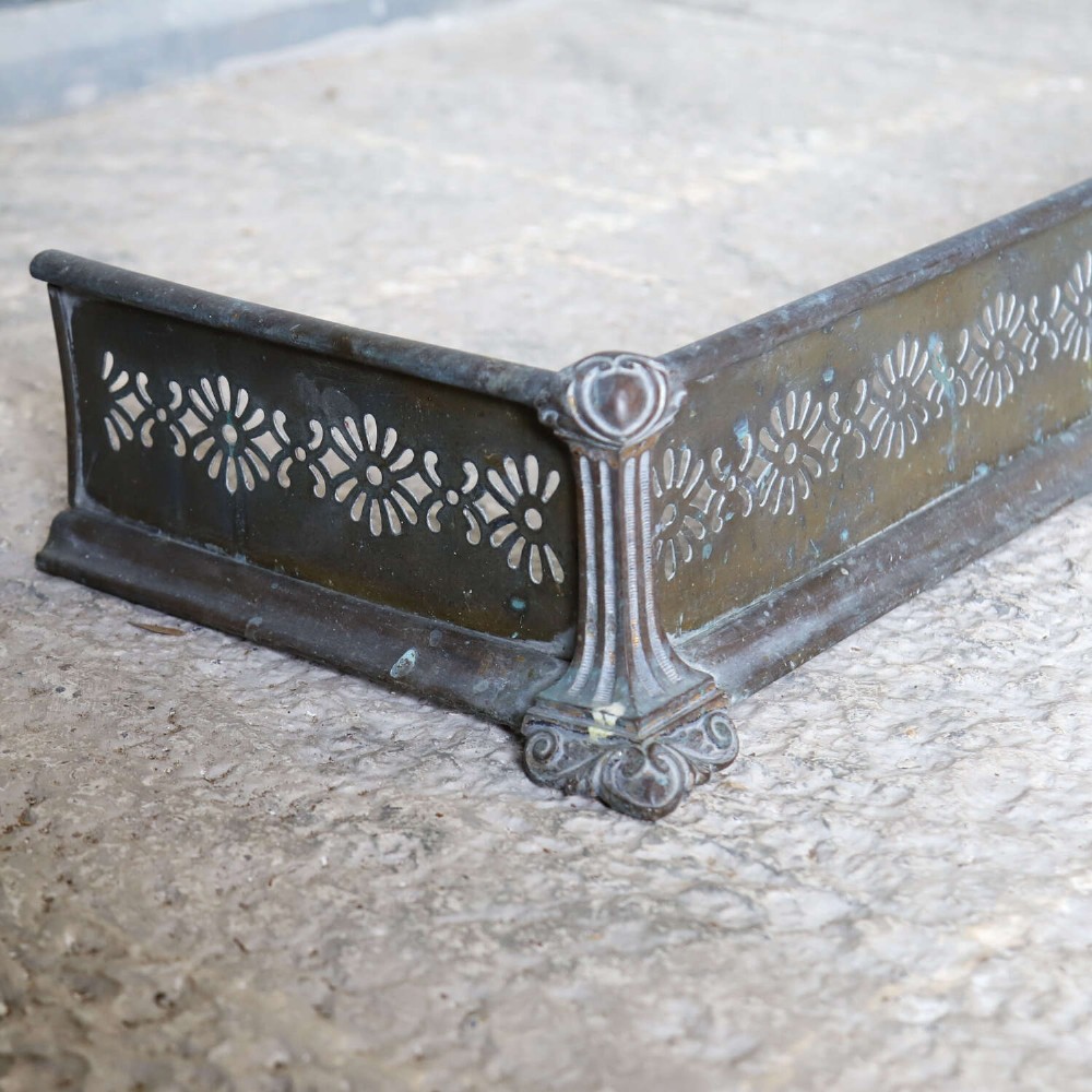 An English Art Nouveau fireplace fender constructed from brass and steel featuring a continuous pierced daisy motif. View VII