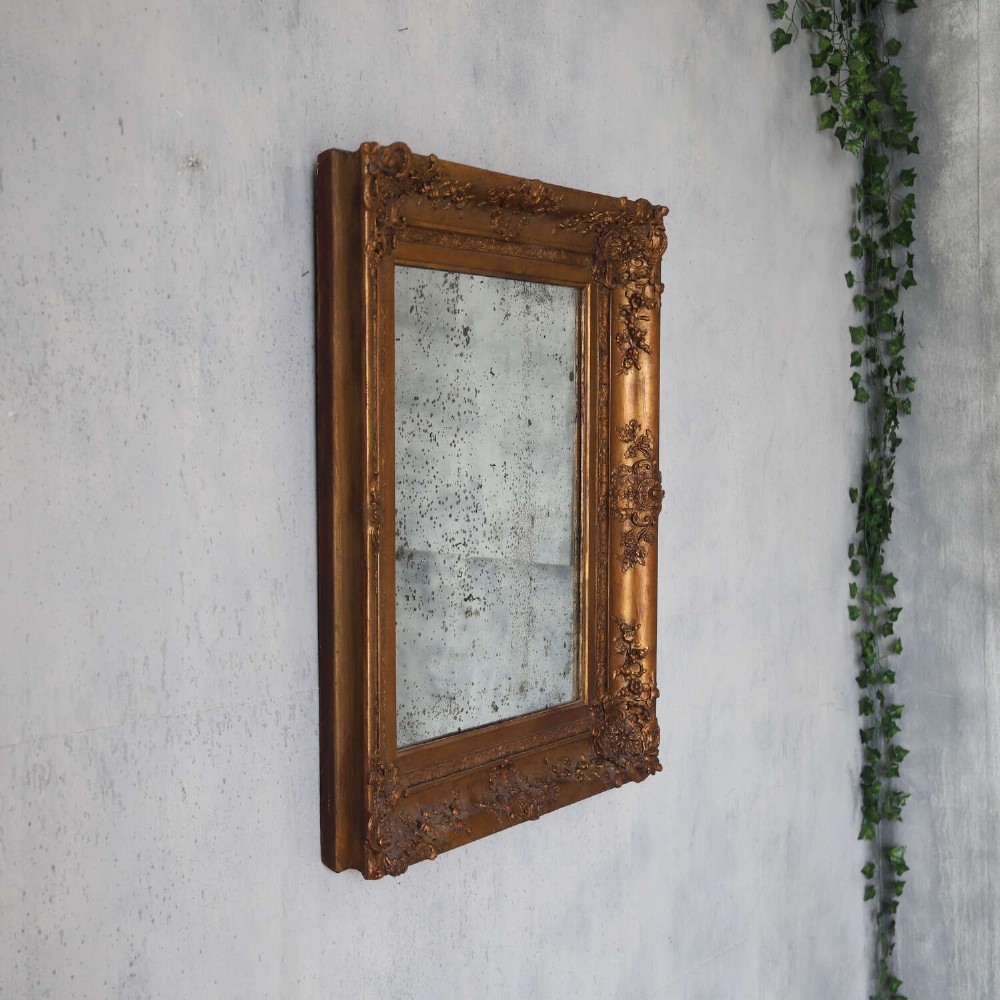 An early 19th-century rectangular wall mirror featuring an ornate gold gilded frame with scrollwork moulding and heavily foxed glass. View III