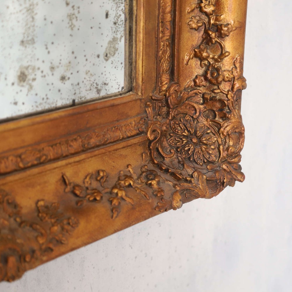 An early 19th-century rectangular wall mirror featuring an ornate gold gilded frame with scrollwork moulding and heavily foxed glass. View IV