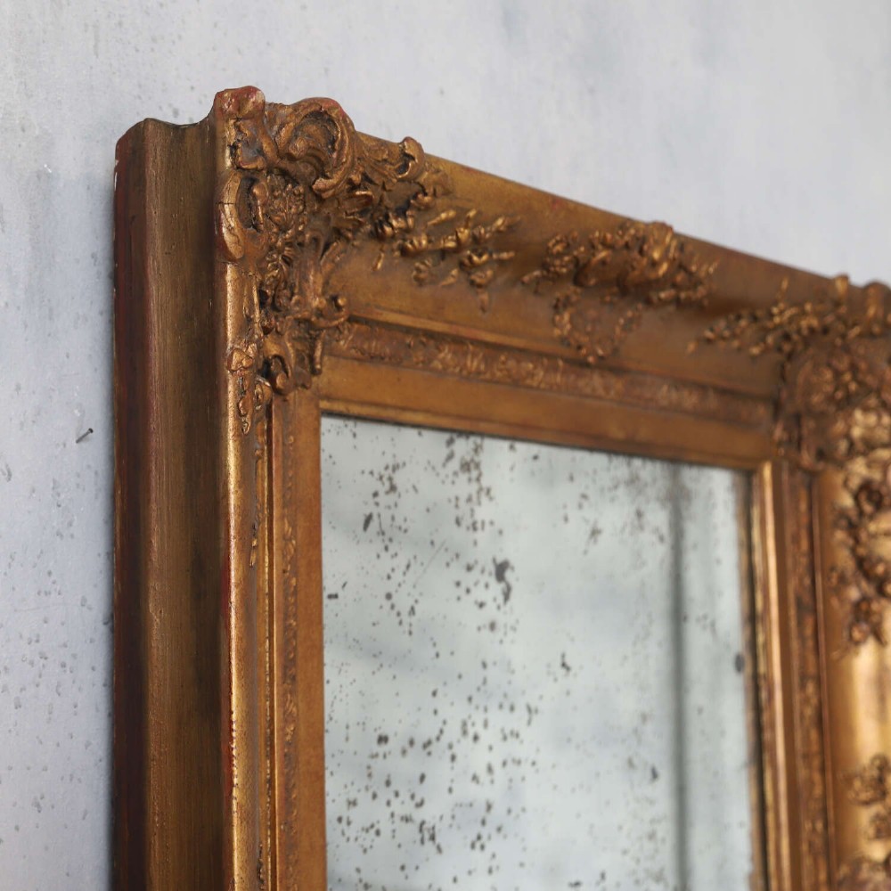 An early 19th-century rectangular wall mirror featuring an ornate gold gilded frame with scrollwork moulding and heavily foxed glass. View VII
