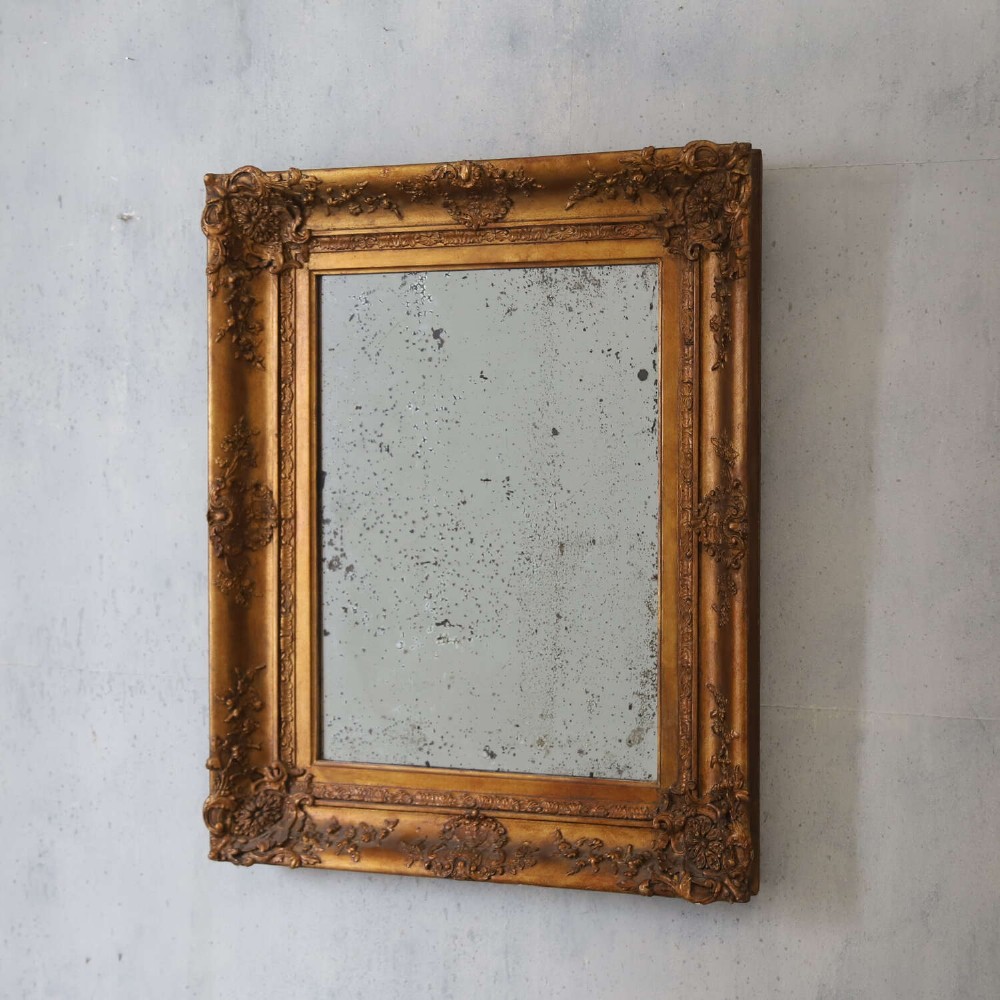 An early 19th-century rectangular wall mirror featuring an ornate gold gilded frame with scrollwork moulding and heavily foxed glass. View VIII
