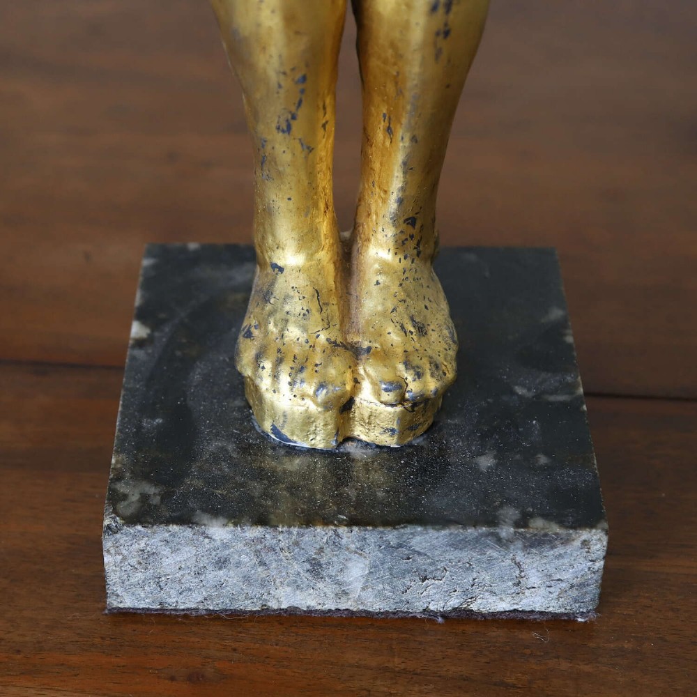 A 19th-century Egyptian Revival gilt wooden standing figure mounted on a dark square stone base. View IV