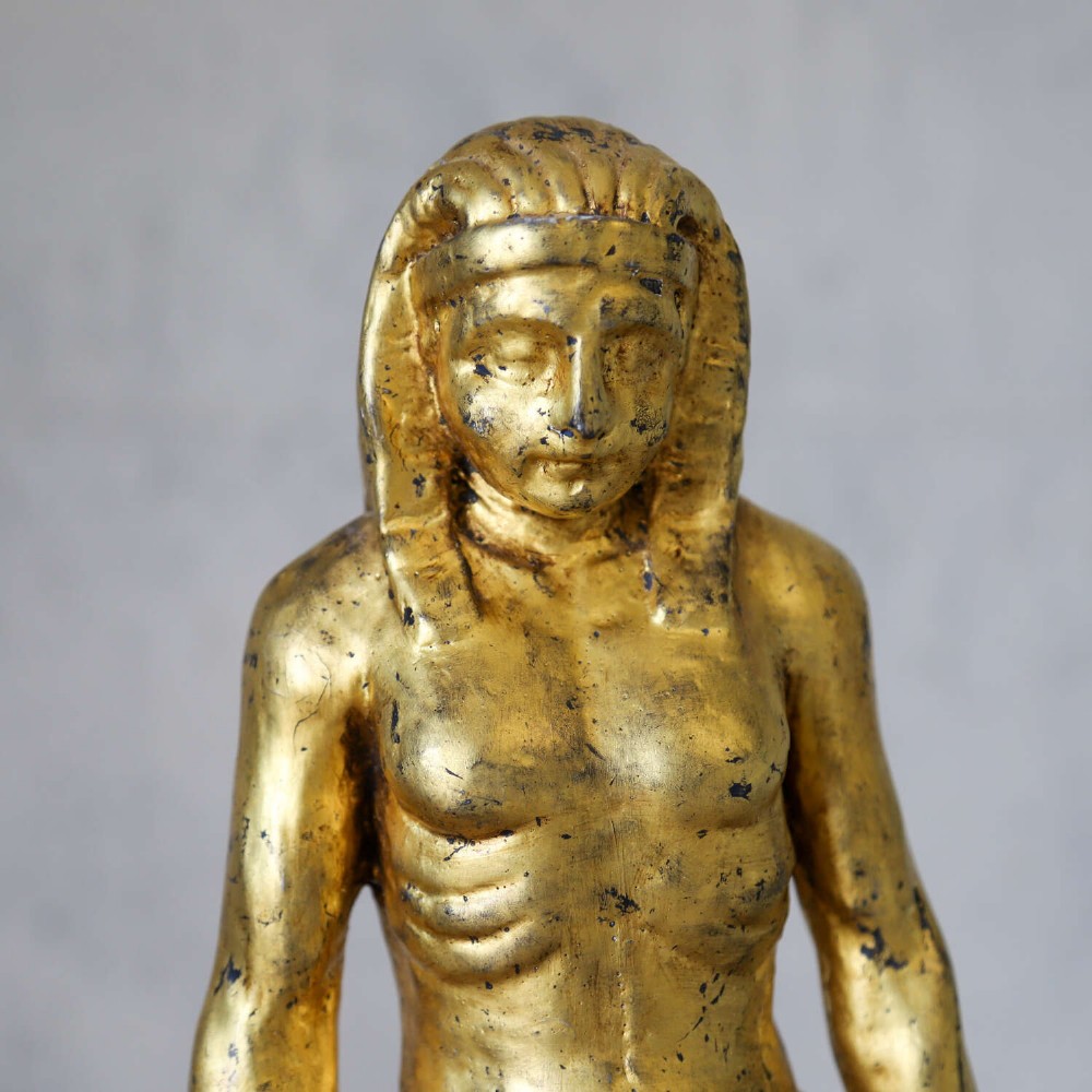 A 19th-century Egyptian Revival gilt wooden standing figure mounted on a dark square stone base. View V