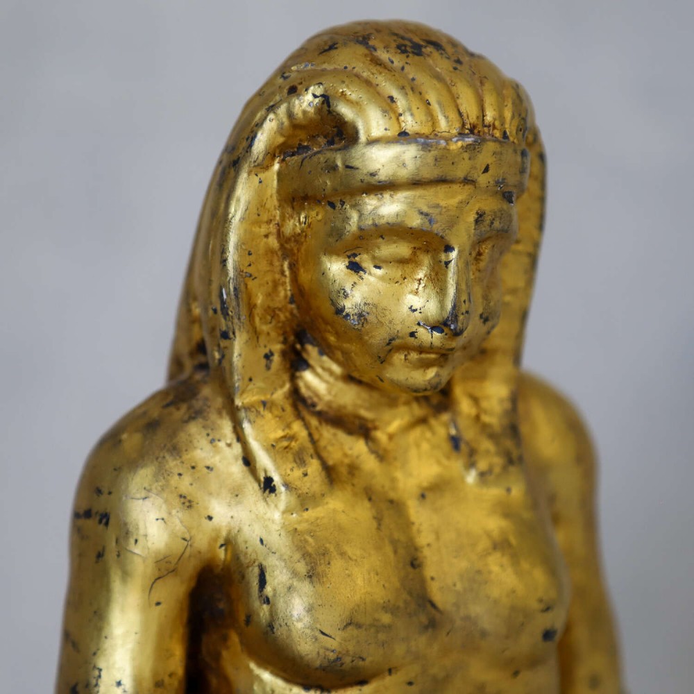 A 19th-century Egyptian Revival gilt wooden standing figure mounted on a dark square stone base. View VIII