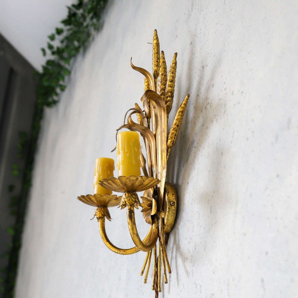 A mid-century gilt metal wall sconce crafted in the form of a wheat sheaf with two candle arms. View X