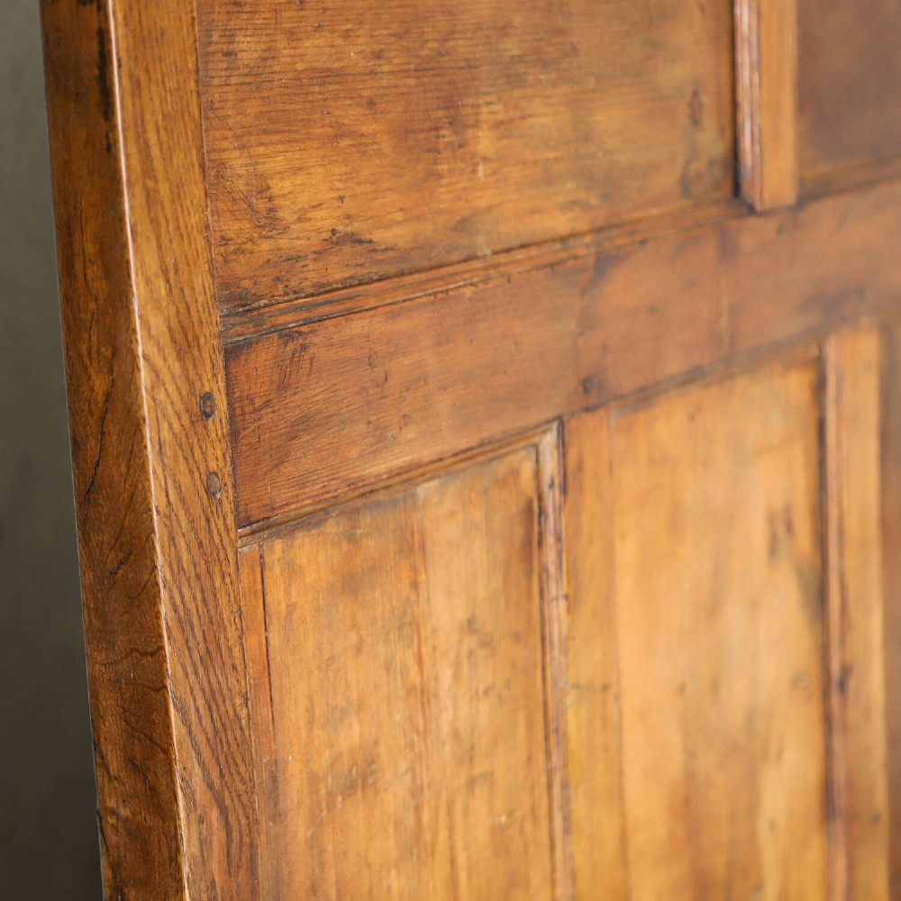 A high-backed antique wooden settle featuring raised timber panels, flat armrests with turned supports, and an enclosed panelled base. View XI