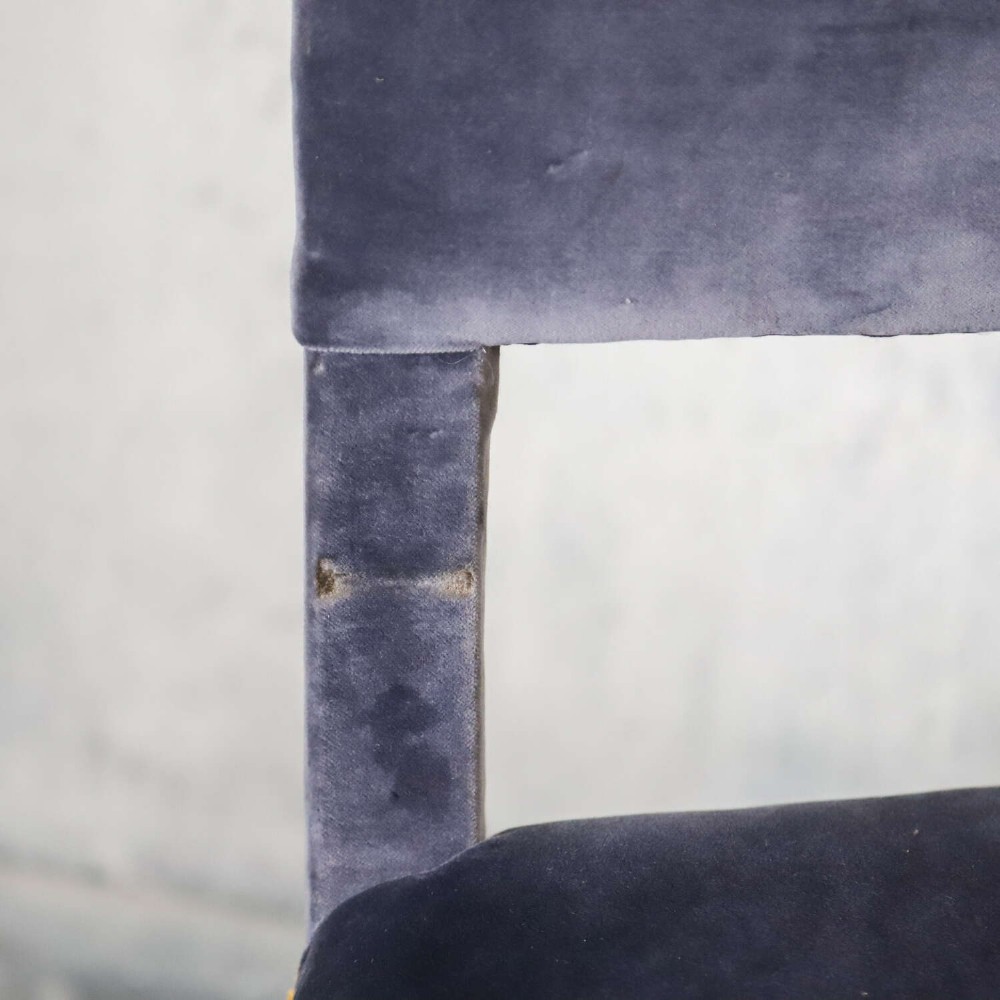 A matched pair of dark oak side chairs upholstered in dark blue velvet, featuring embroidered heraldic crests on the backrests and gold tassel fringe around the seat borders. View VIII