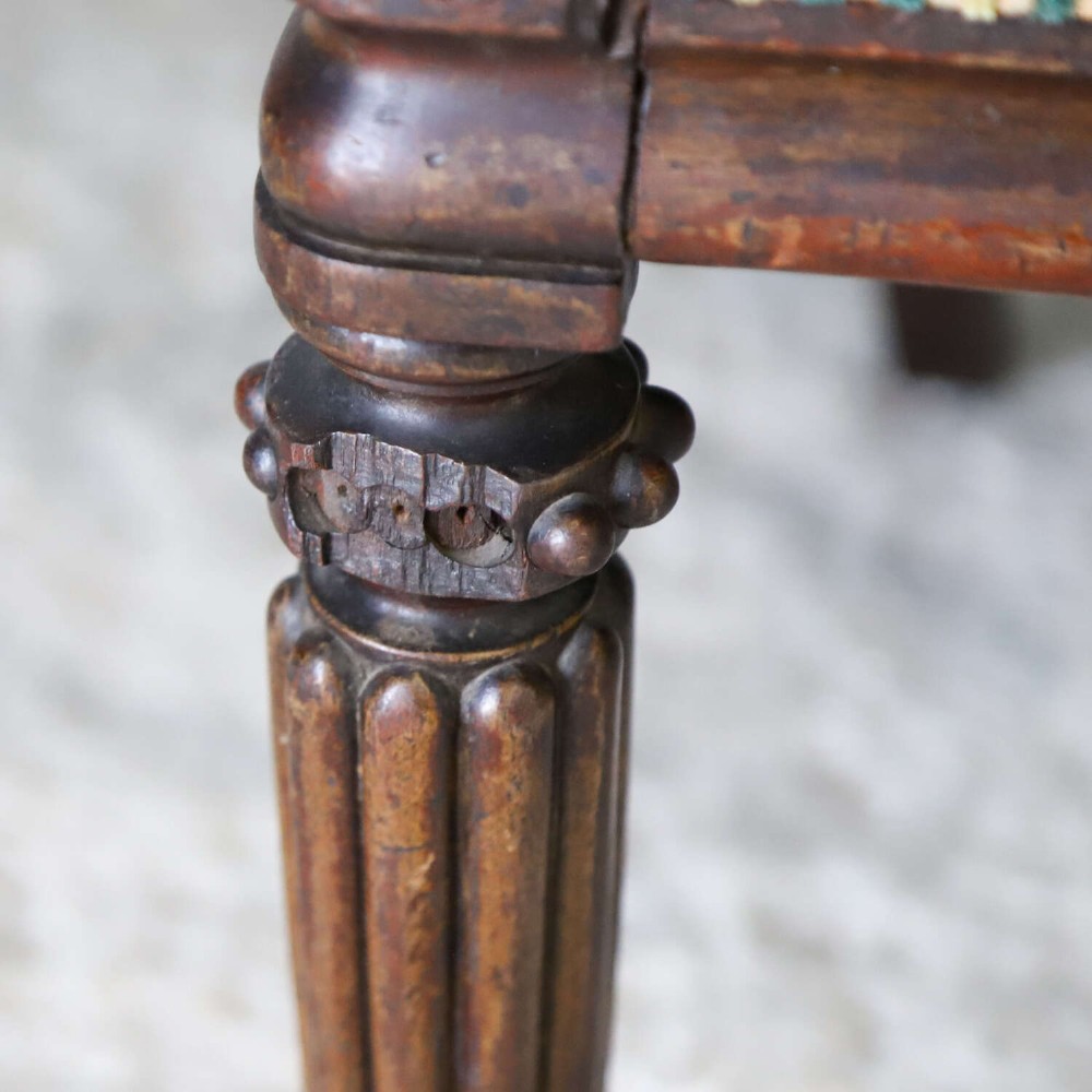 A pair of William IV mahogany side chairs featuring curved top rails with relief carving, fluted front legs, and seats upholstered in green and gold striped fabric. View IV