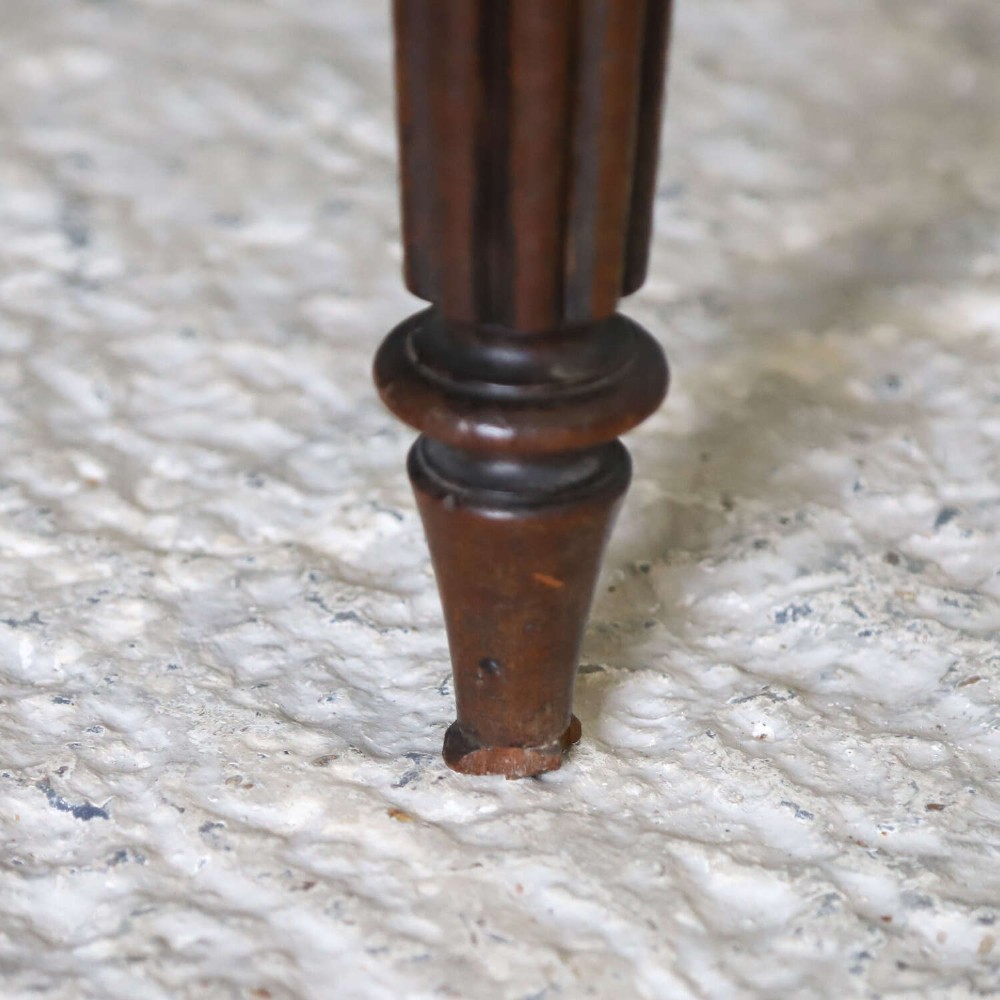 A pair of William IV mahogany side chairs featuring curved top rails with relief carving, fluted front legs, and seats upholstered in green and gold striped fabric. View VI