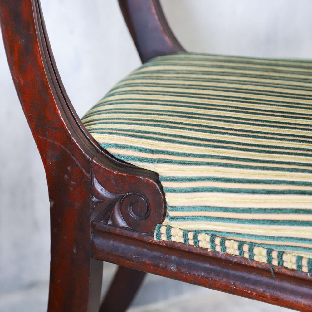 A pair of William IV mahogany side chairs featuring curved top rails with relief carving, fluted front legs, and seats upholstered in green and gold striped fabric. View XI