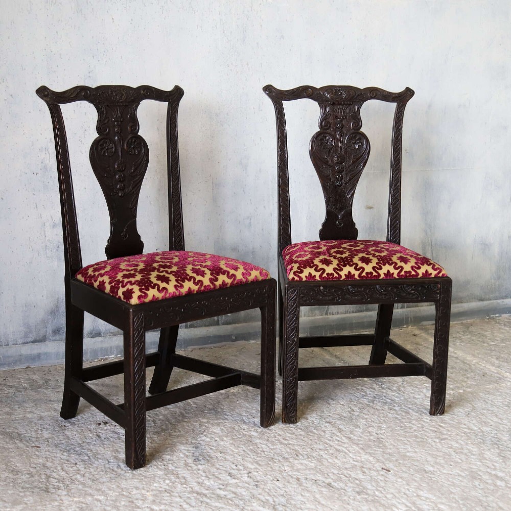 A pair of dark carved oak side chairs with vasiform splats and seats upholstered in red and gold patterned velvet. View III