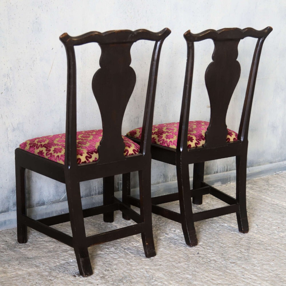 A pair of dark carved oak side chairs with vasiform splats and seats upholstered in red and gold patterned velvet. View IX