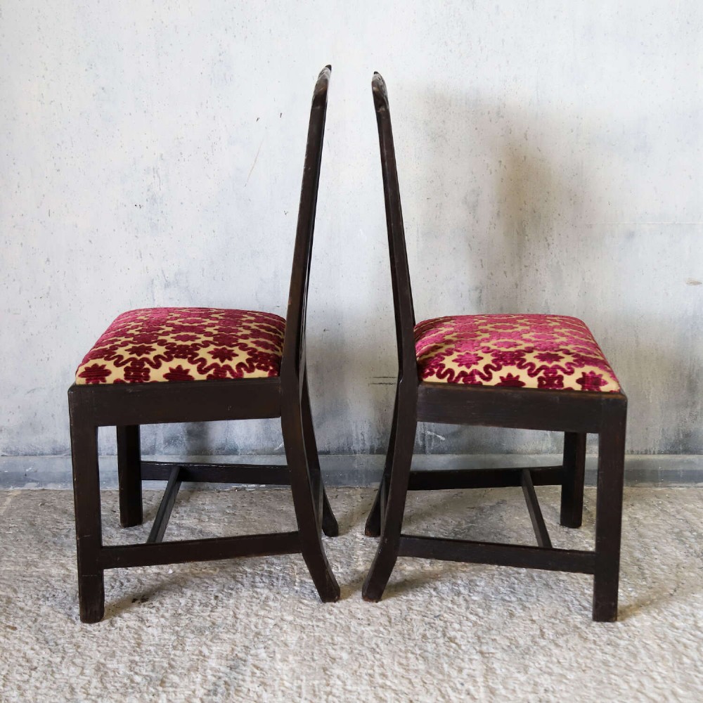 A pair of dark carved oak side chairs with vasiform splats and seats upholstered in red and gold patterned velvet. View X