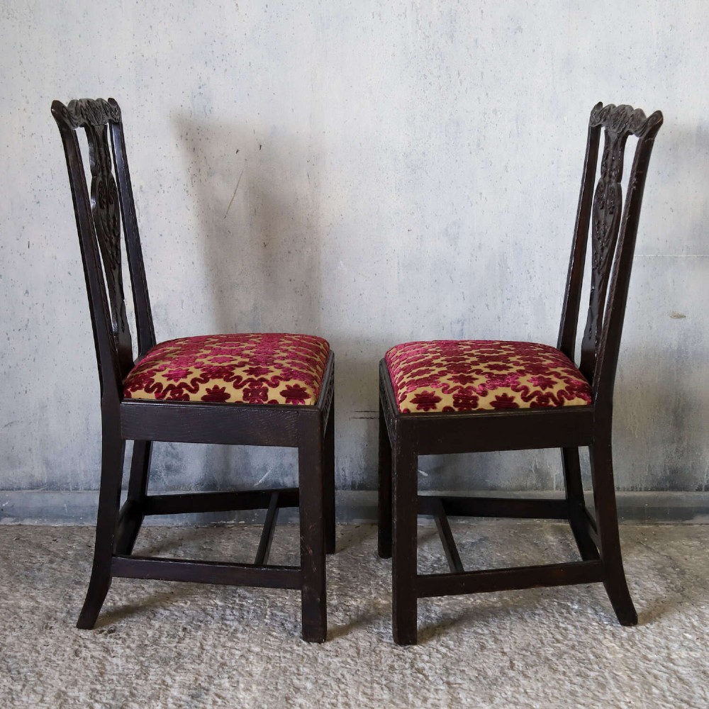 A pair of dark carved oak side chairs with vasiform splats and seats upholstered in red and gold patterned velvet. View XI