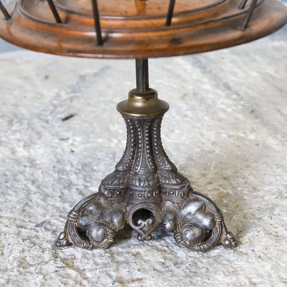 A four-tiered Victorian cotton reel display tree featuring circular wooden tiers with vertical metal spindles set on a cast iron base. View IV