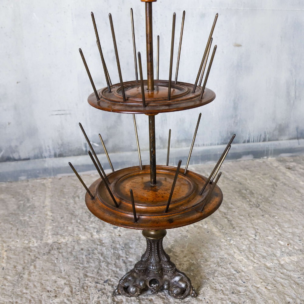 A four-tiered Victorian cotton reel display tree featuring circular wooden tiers with vertical metal spindles set on a cast iron base. View V