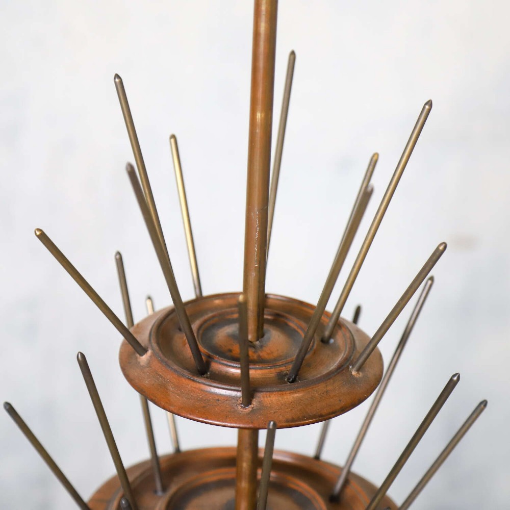 A four-tiered Victorian cotton reel display tree featuring circular wooden tiers with vertical metal spindles set on a cast iron base. View VII