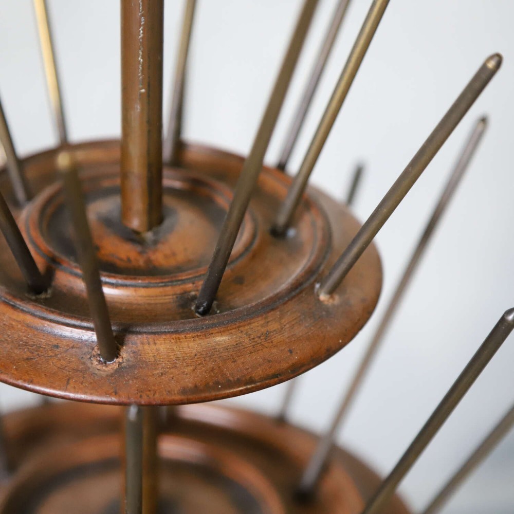 A four-tiered Victorian cotton reel display tree featuring circular wooden tiers with vertical metal spindles set on a cast iron base. View VIII