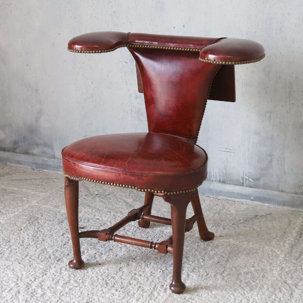 A late Victorian Sheraton style reading chair upholstered in burgundy red leather with brass studding and mahogany legs. View II