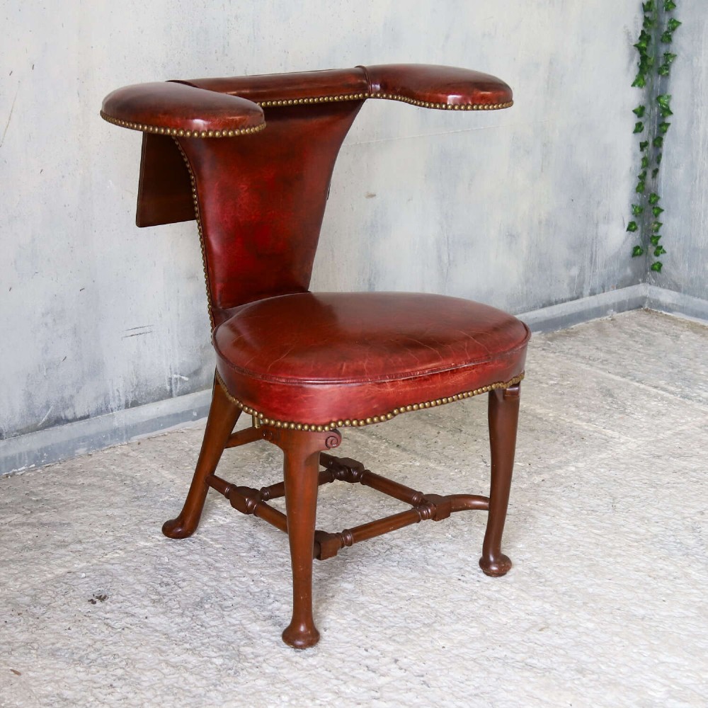 A late Victorian Sheraton style reading chair upholstered in burgundy red leather with brass studding and mahogany legs. View III