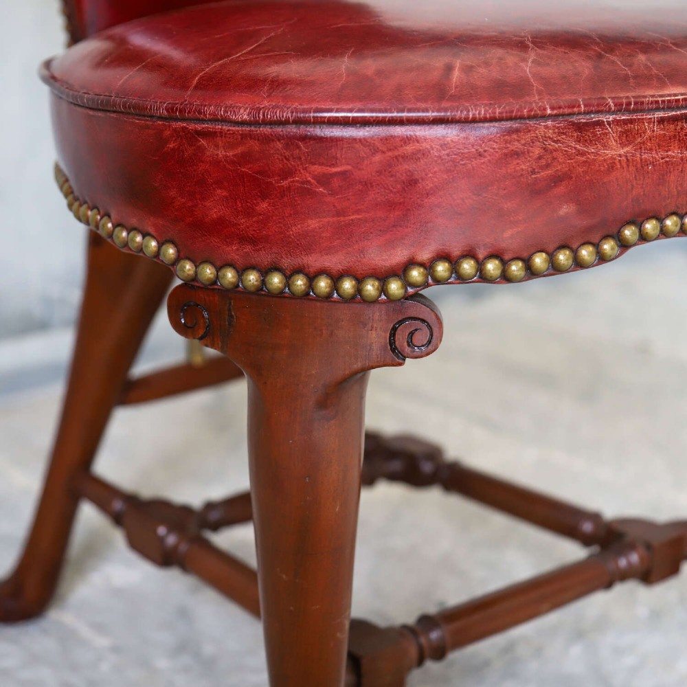 A late Victorian Sheraton style reading chair upholstered in burgundy red leather with brass studding and mahogany legs. View IV