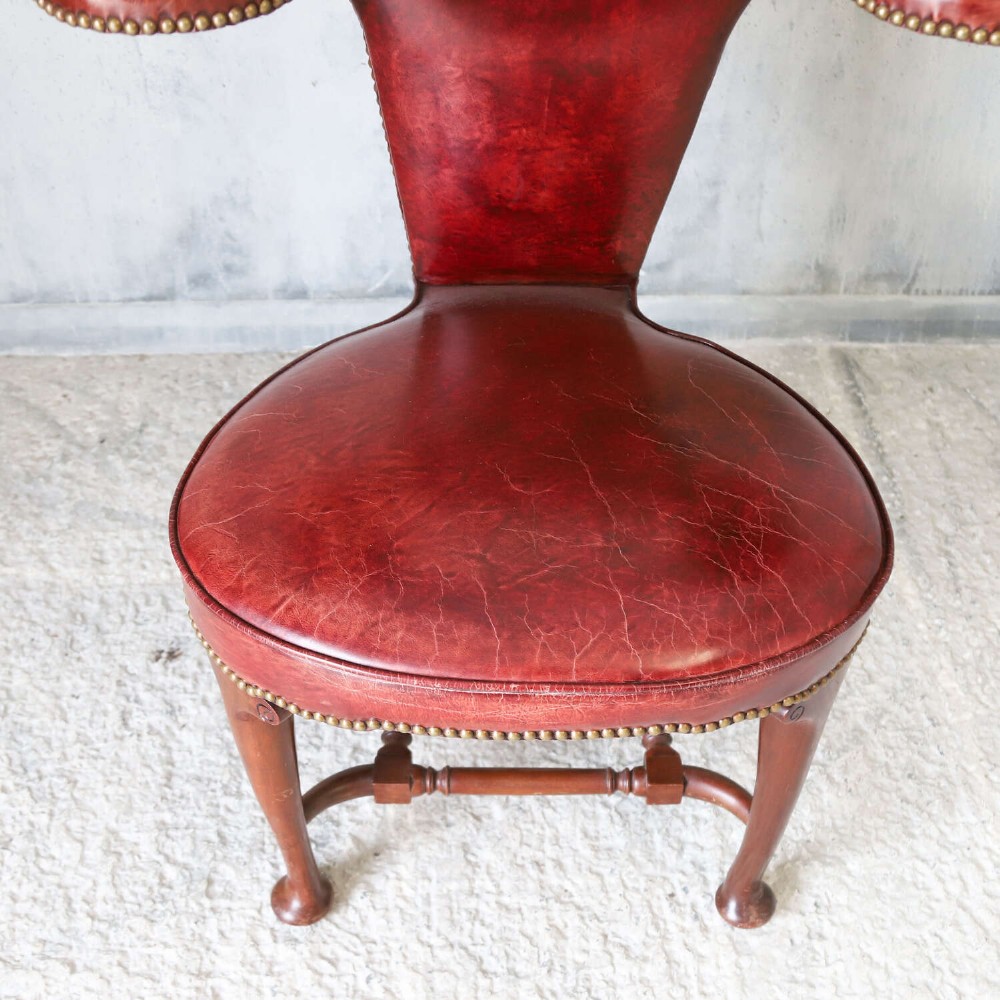 A late Victorian Sheraton style reading chair upholstered in burgundy red leather with brass studding and mahogany legs. View IX