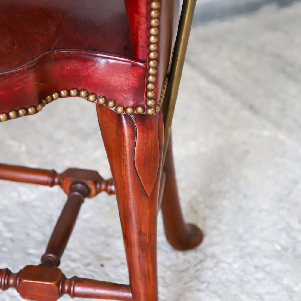A late Victorian Sheraton style reading chair upholstered in burgundy red leather with brass studding and mahogany legs. View XI