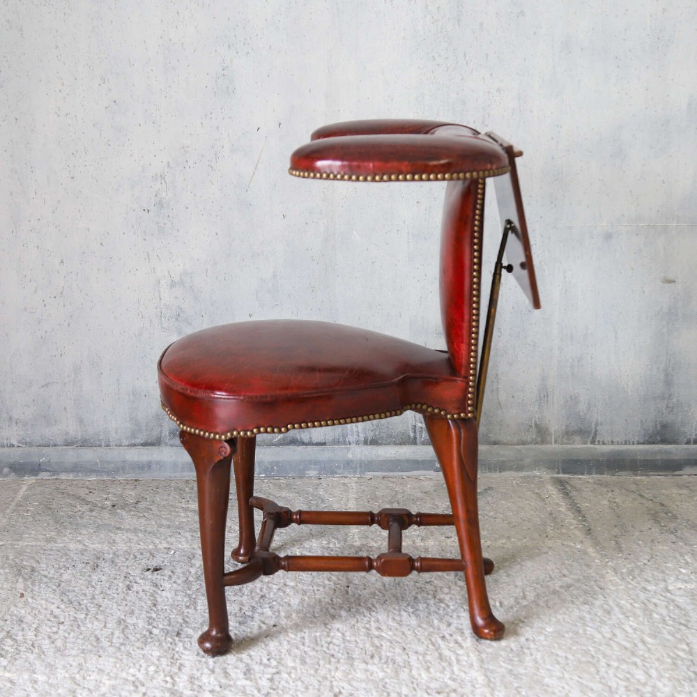 A late Victorian Sheraton style reading chair upholstered in burgundy red leather with brass studding and mahogany legs. View XIV