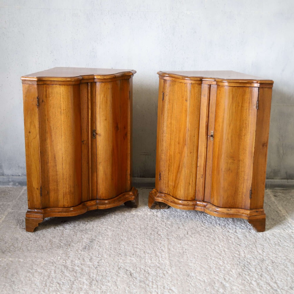 A matching pair of 18th-century Italian walnut corner cupboards with serpentine fronts and brass keyhole escutcheons. View II