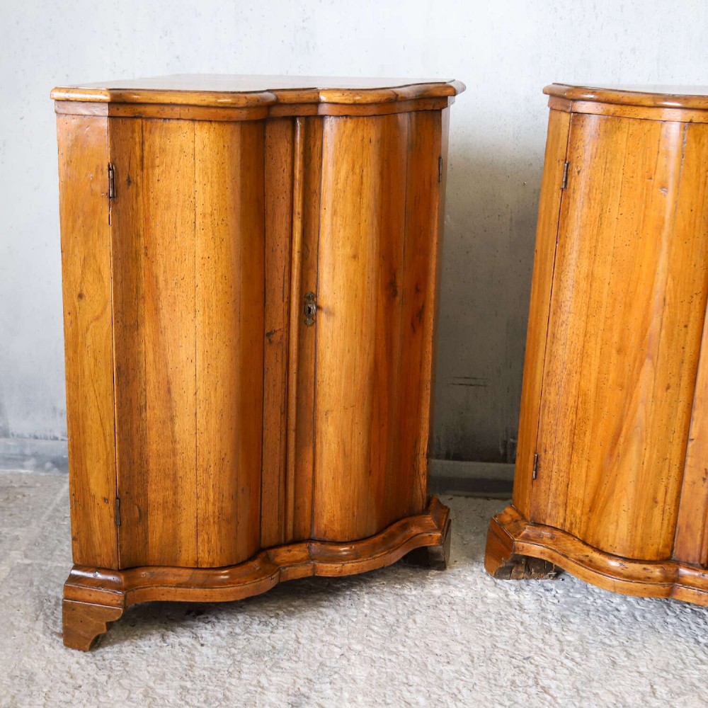 A matching pair of 18th-century Italian walnut corner cupboards with serpentine fronts and brass keyhole escutcheons. View III