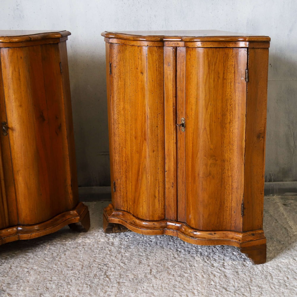 A matching pair of 18th-century Italian walnut corner cupboards with serpentine fronts and brass keyhole escutcheons. View IV