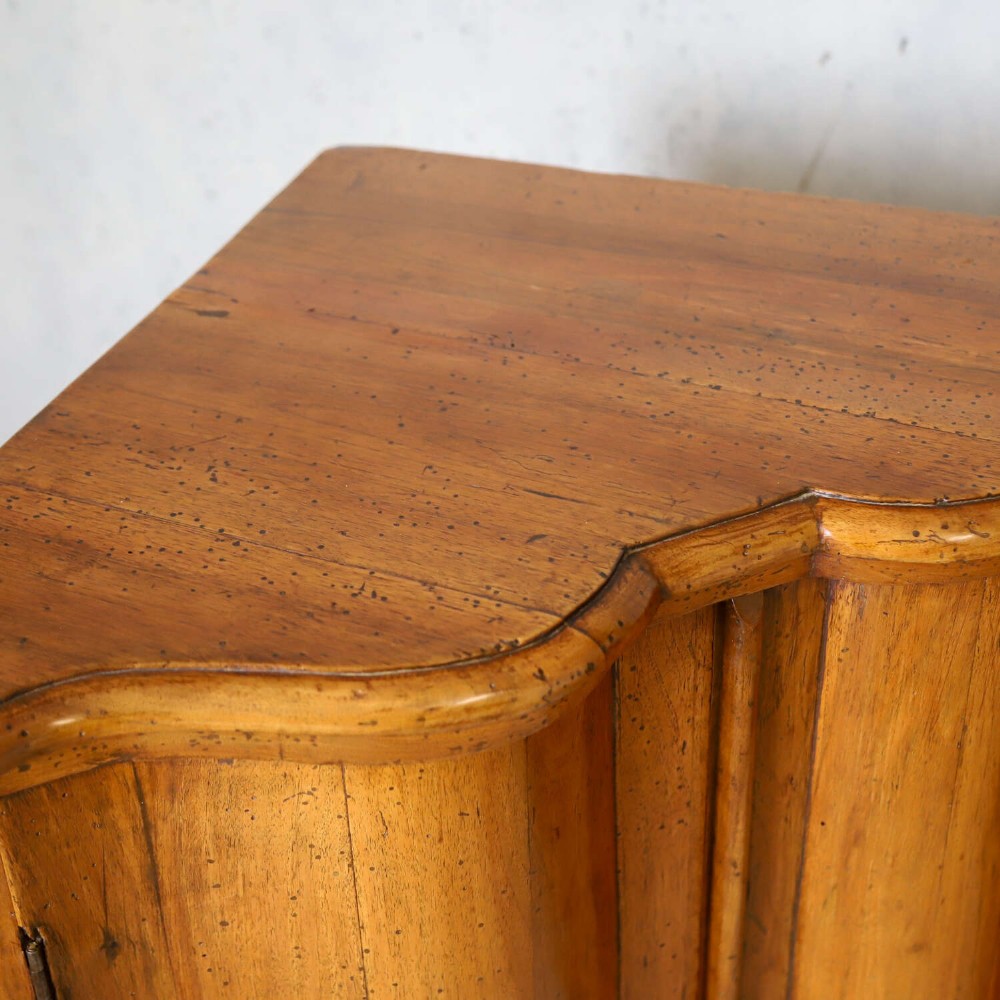 A matching pair of 18th-century Italian walnut corner cupboards with serpentine fronts and brass keyhole escutcheons. View VI