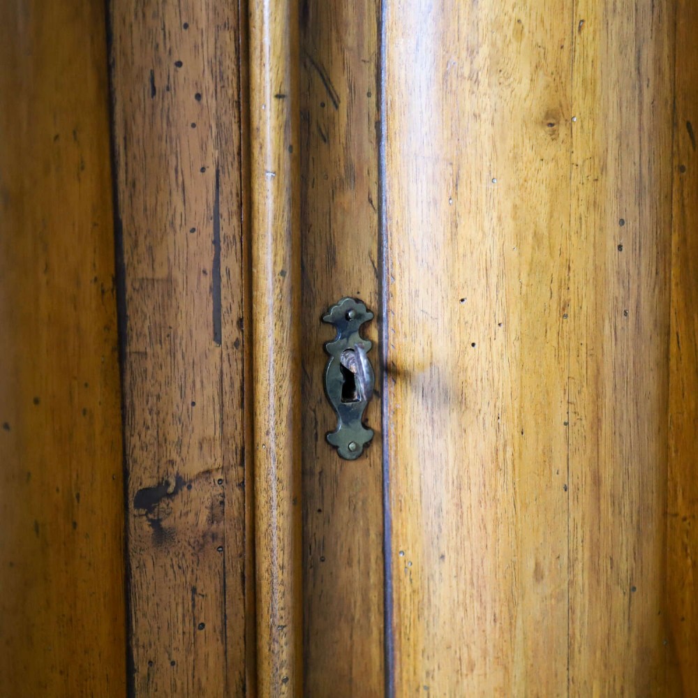 A matching pair of 18th-century Italian walnut corner cupboards with serpentine fronts and brass keyhole escutcheons. View VII