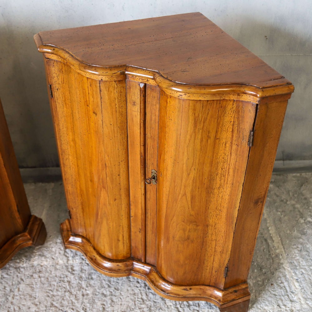 A matching pair of 18th-century Italian walnut corner cupboards with serpentine fronts and brass keyhole escutcheons. View VIII