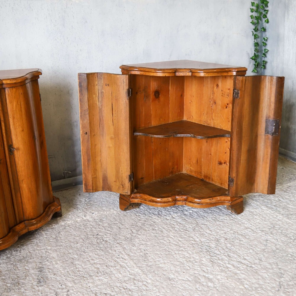 A matching pair of 18th-century Italian walnut corner cupboards with serpentine fronts and brass keyhole escutcheons. View IX