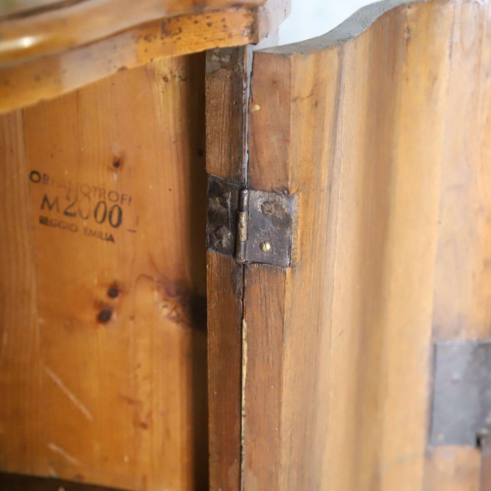 A matching pair of 18th-century Italian walnut corner cupboards with serpentine fronts and brass keyhole escutcheons. View X