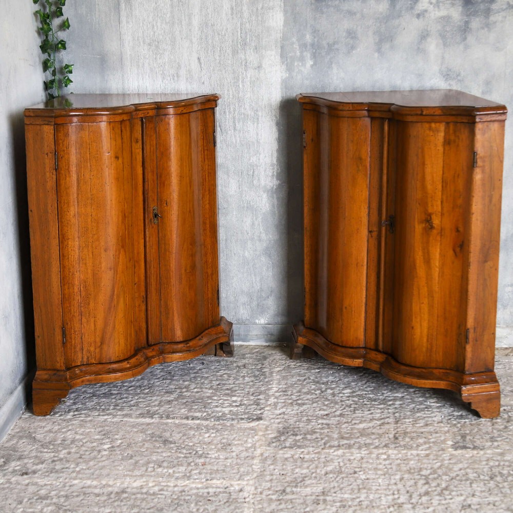 A matching pair of 18th-century Italian walnut corner cupboards with serpentine fronts and brass keyhole escutcheons. View XIV