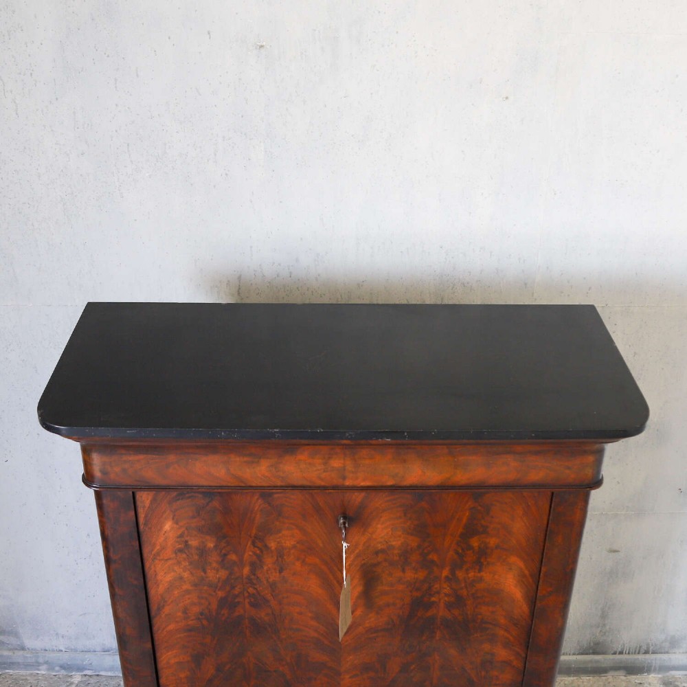 A 19th-century French secretaire a abattant featuring flame mahogany veneers, a dark marble top slab, an upper drop-front writing panel, and lower cupboard doors. View XIV