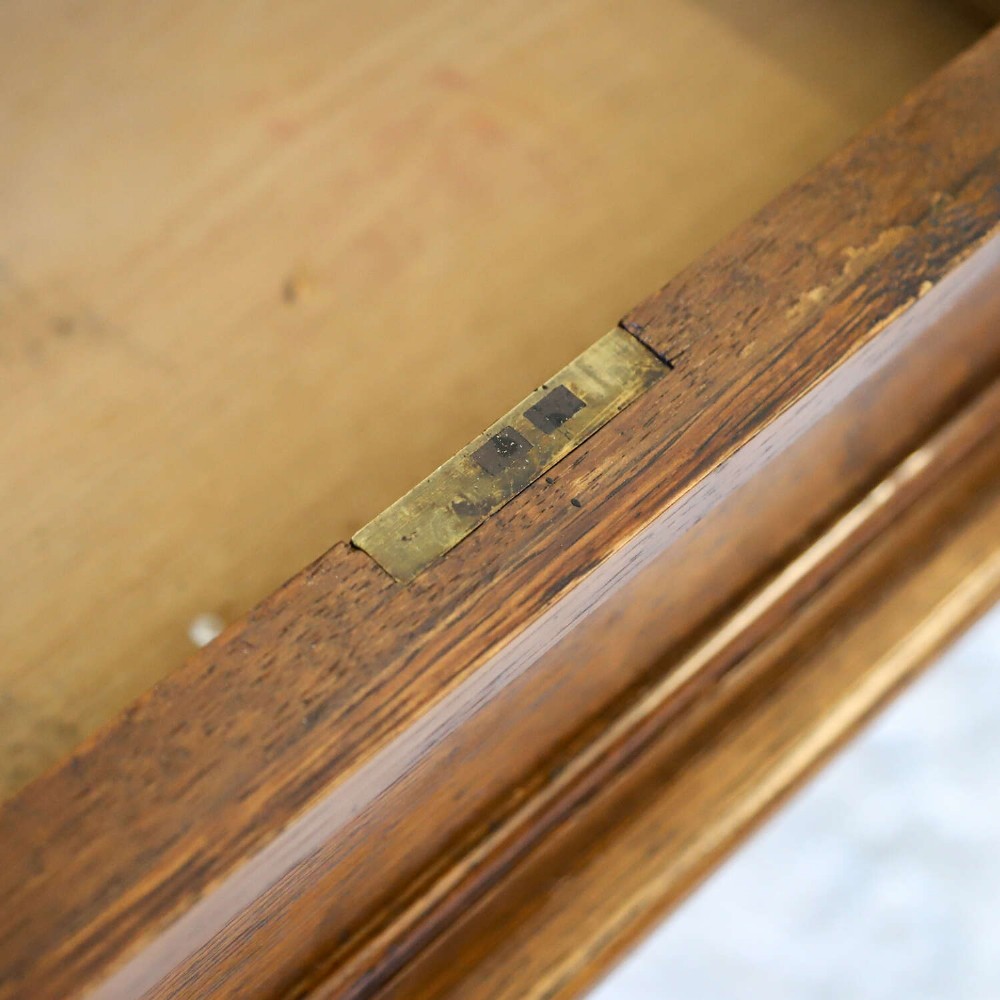 A 19th-century English oak Gothic Revival library table featuring an inset leather top and carved turned legs on brass castors. View VII