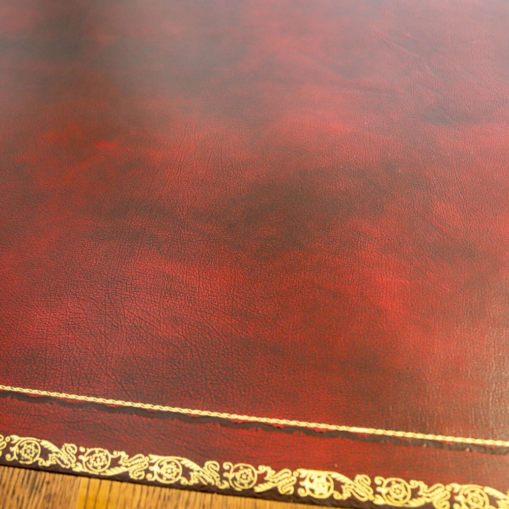 A 19th-century English oak Gothic Revival library table featuring an inset leather top and carved turned legs on brass castors. View XIV