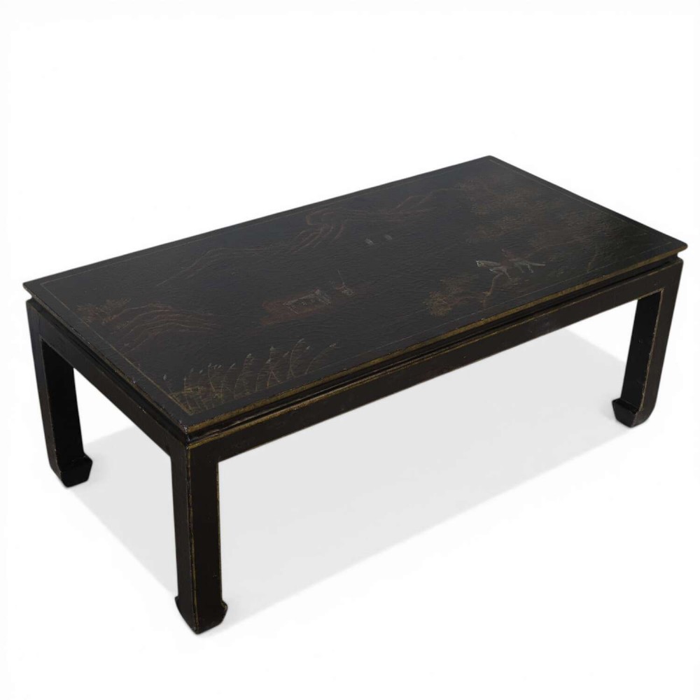 A low rectangular black japanned coffee table decorated with hand-painted gilt landscape scenes and supported by straight legs.