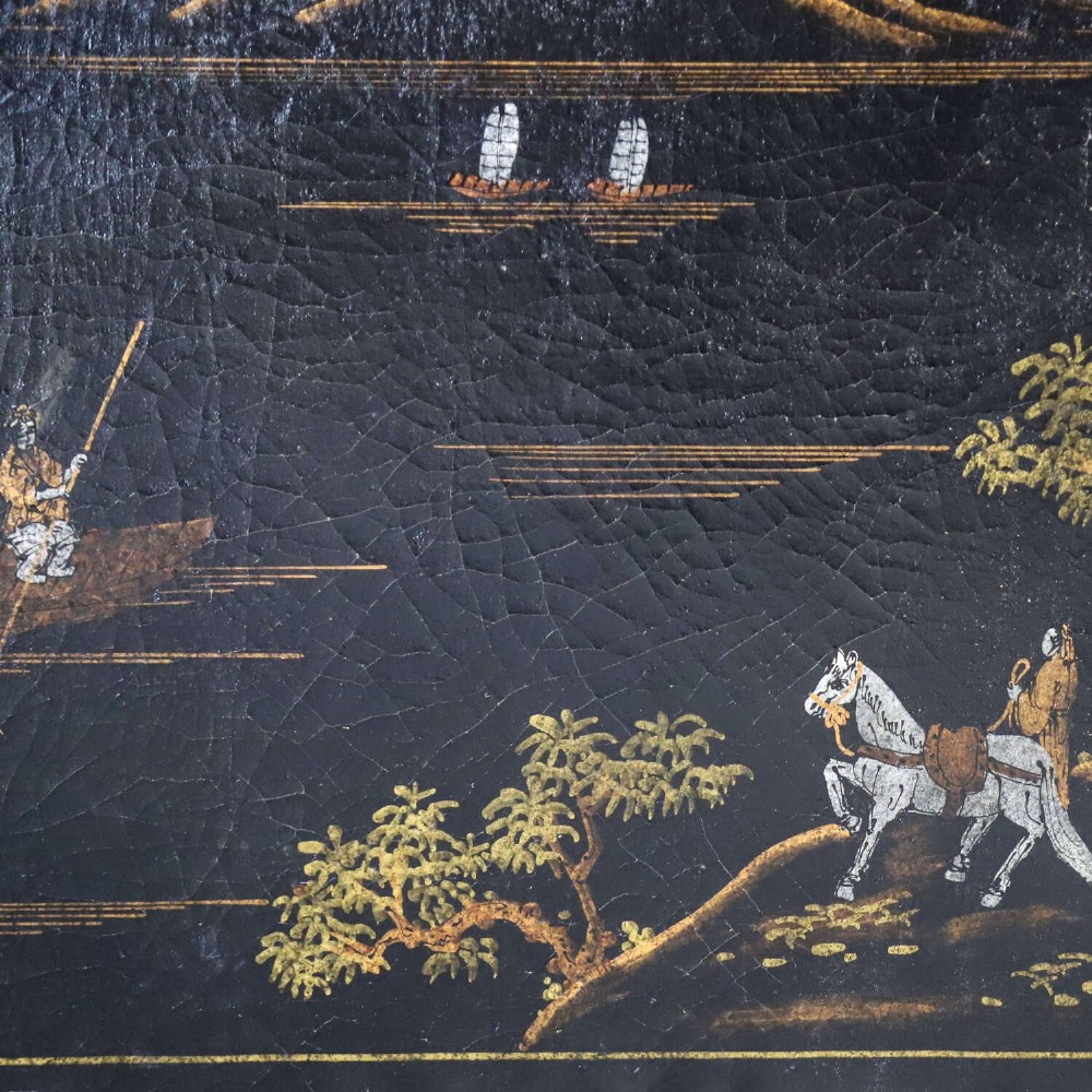 A low rectangular black japanned coffee table decorated with hand-painted gilt landscape scenes and supported by straight legs. View III