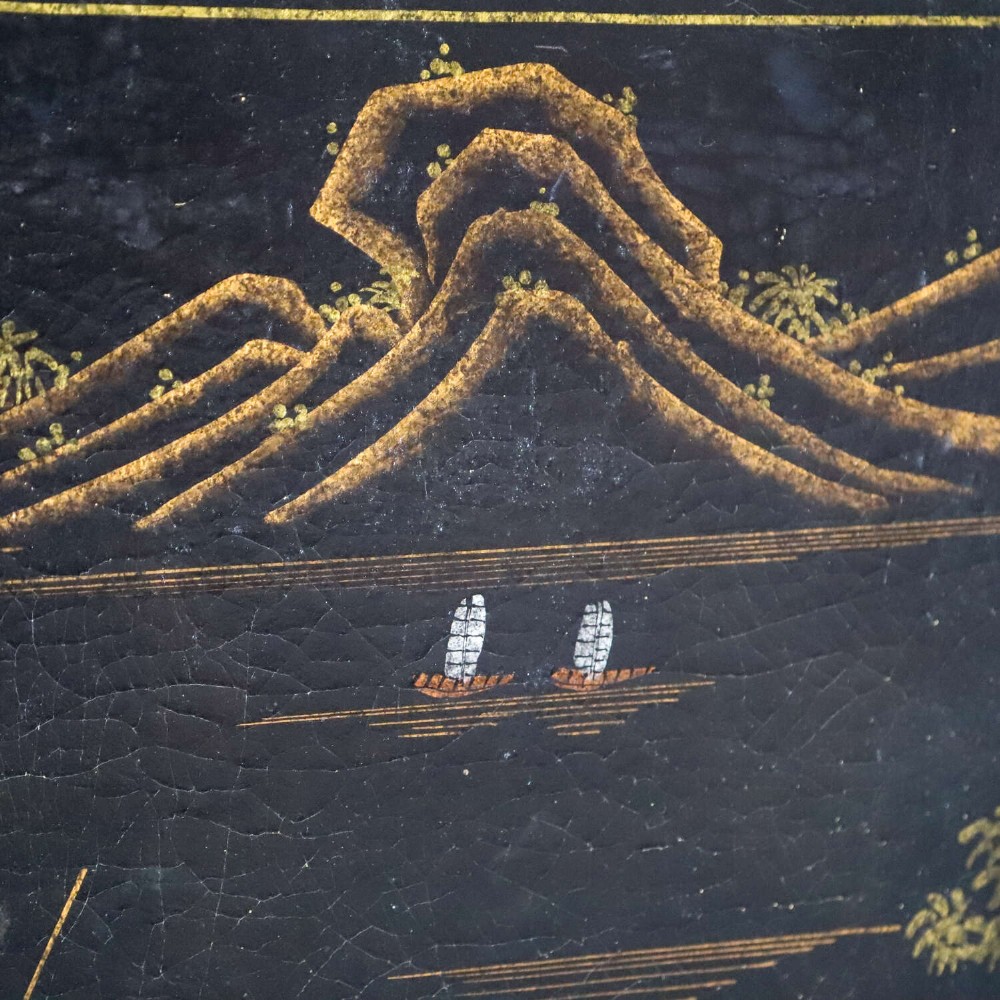 A low rectangular black japanned coffee table decorated with hand-painted gilt landscape scenes and supported by straight legs. View V