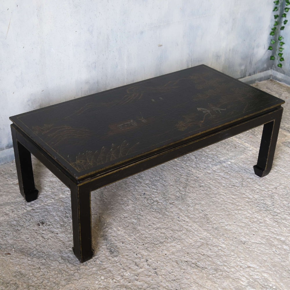 A low rectangular black japanned coffee table decorated with hand-painted gilt landscape scenes and supported by straight legs. View VII