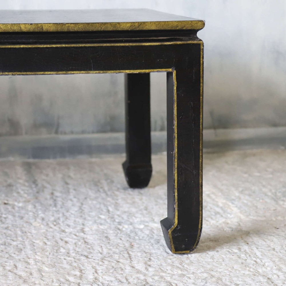 A low rectangular black japanned coffee table decorated with hand-painted gilt landscape scenes and supported by straight legs. View IX