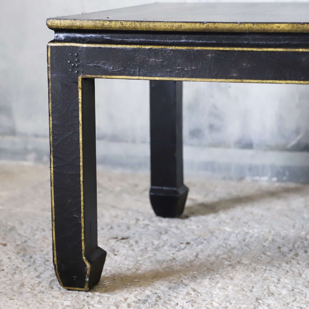 A low rectangular black japanned coffee table decorated with hand-painted gilt landscape scenes and supported by straight legs. View X