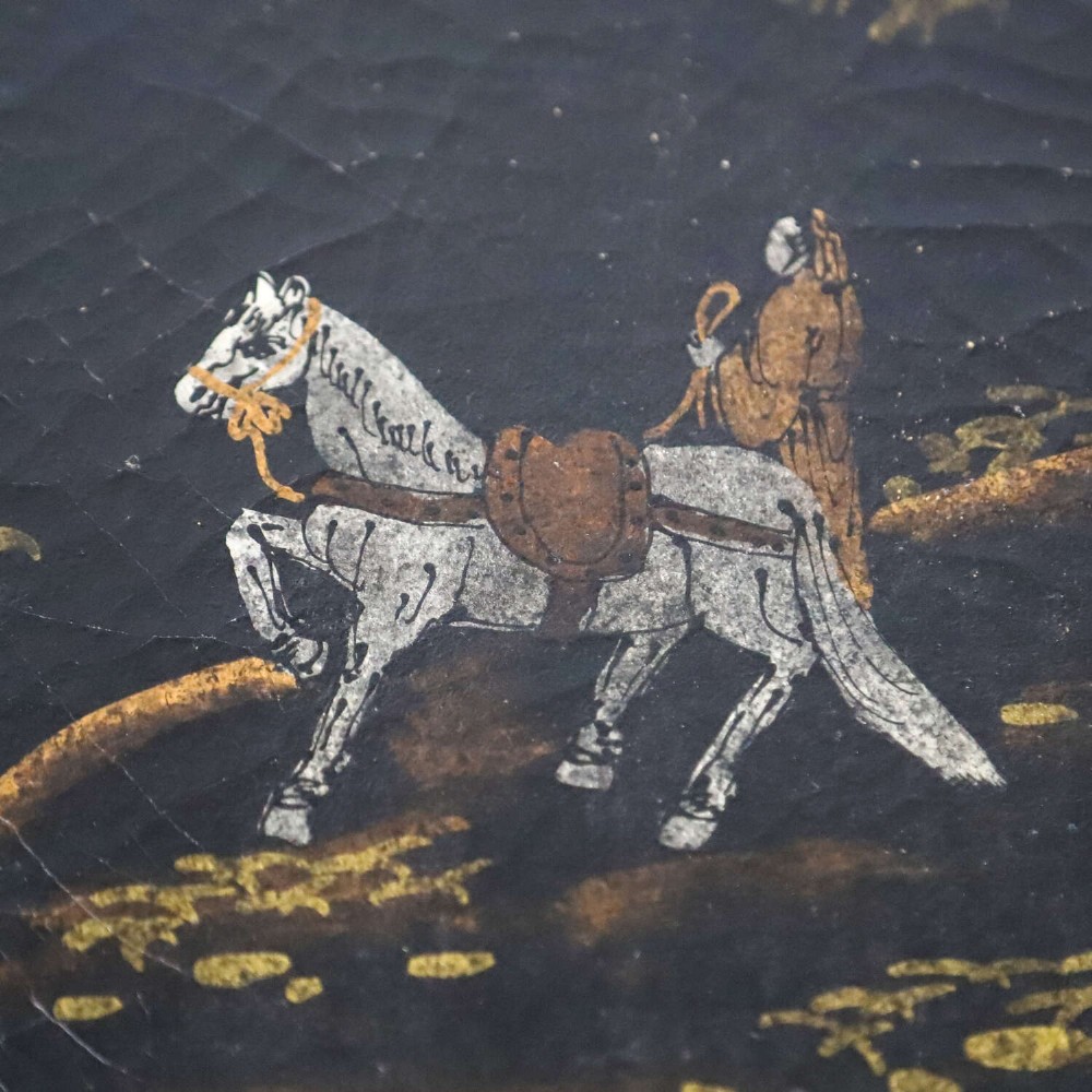 A low rectangular black japanned coffee table decorated with hand-painted gilt landscape scenes and supported by straight legs. View XI