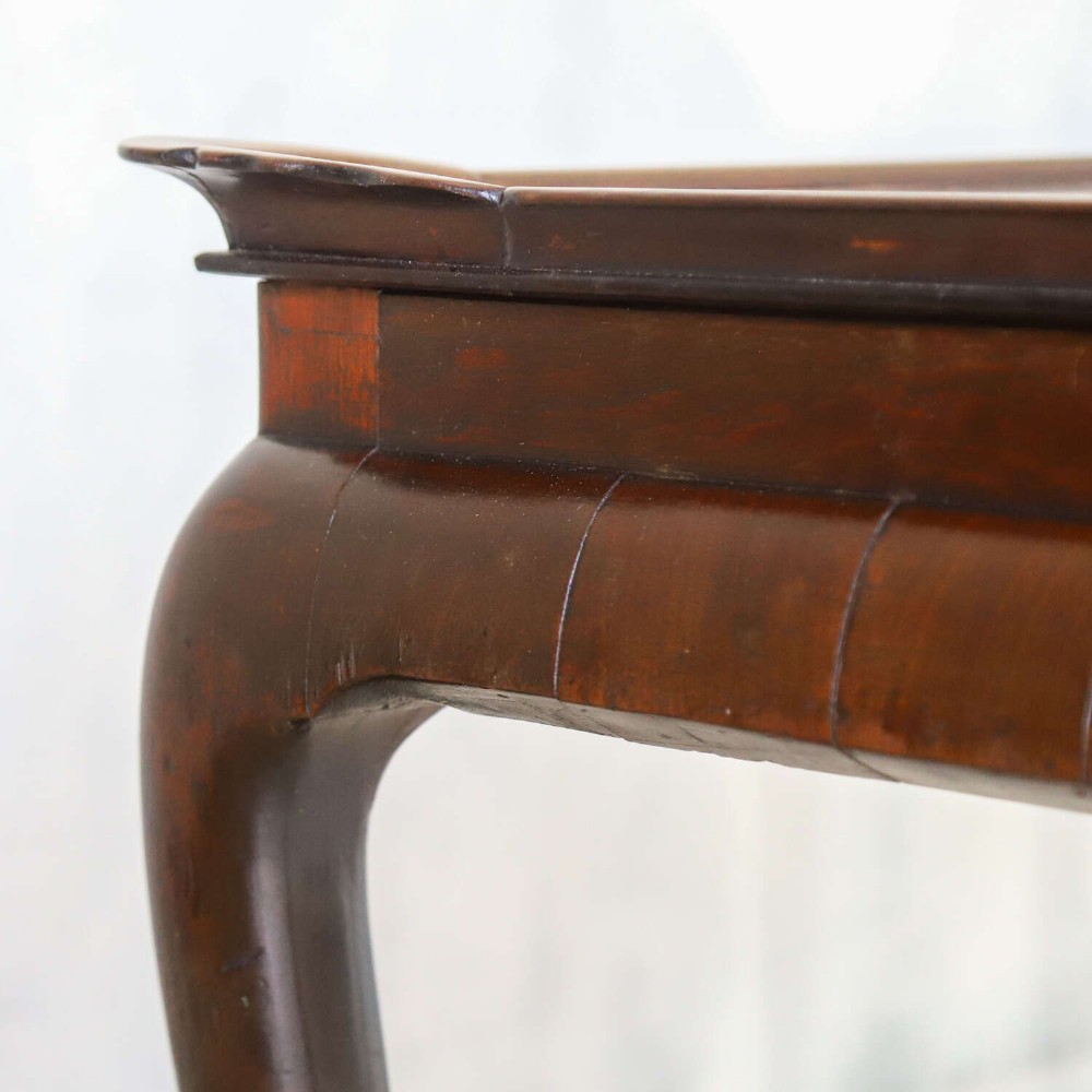 An early Georgian dark Cuban mahogany silver table featuring a raised tray top rim, single drawer with brass escutcheon, and slender cabriole legs terminating in pad feet. View VIII
