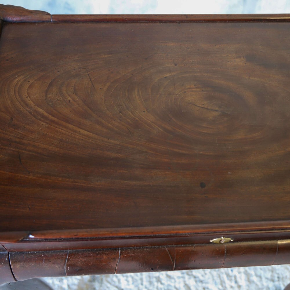 An early Georgian dark Cuban mahogany silver table featuring a raised tray top rim, single drawer with brass escutcheon, and slender cabriole legs terminating in pad feet. View XII