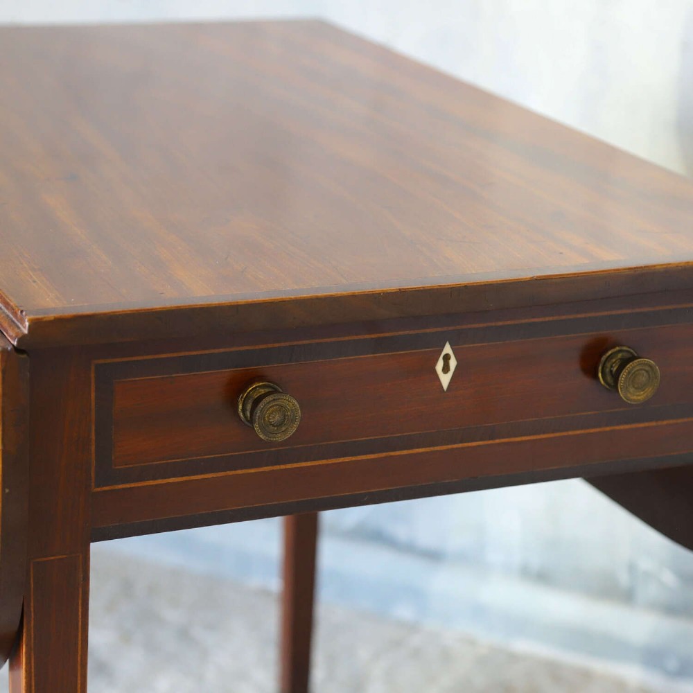 A late 18th-century Sheraton style mahogany Pembroke table with drop leaves, a single drawer, partridge wood crossbanding, and tapered legs on brass castors. View II